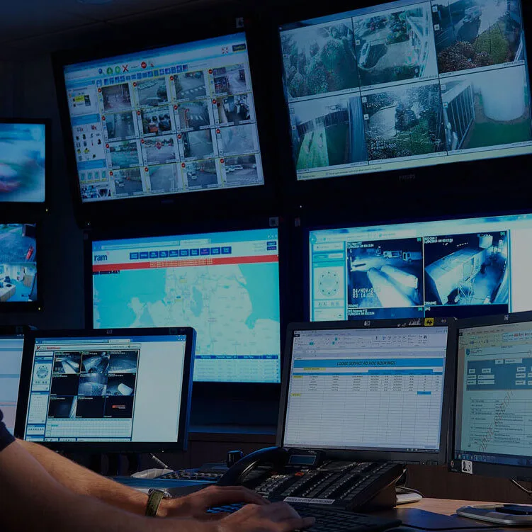 Screens on a wall inside a 24/7 monitoring station